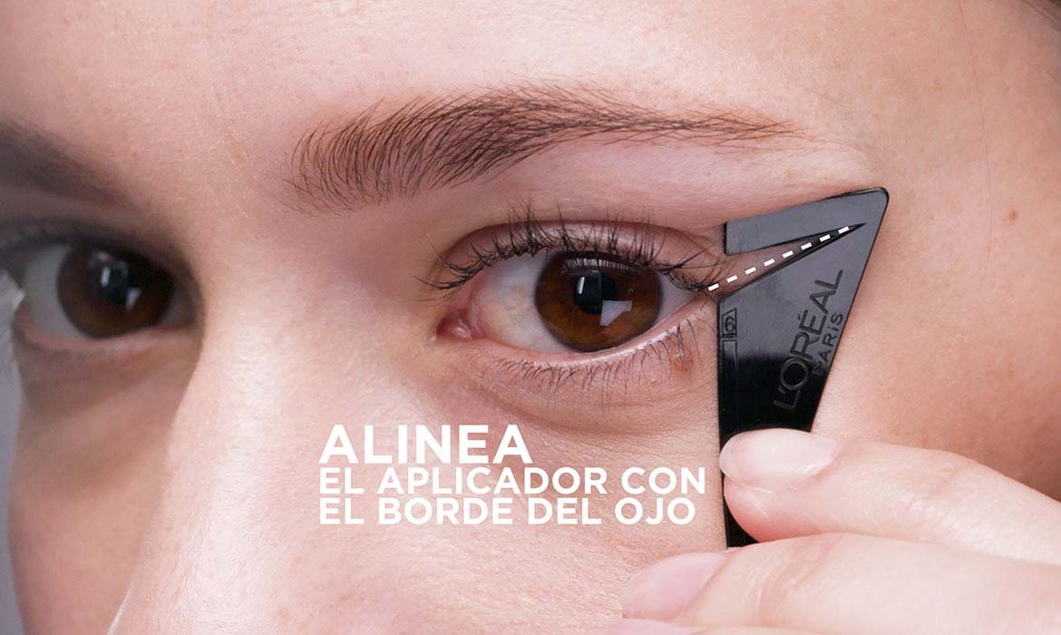 Coloca la plantilla del eyeliner Flash Cat Eye de L’Oréal Paris alineada con el borde de tu ojo y rellénala para dar forma al rabillo característico de la tendencia cat eye.